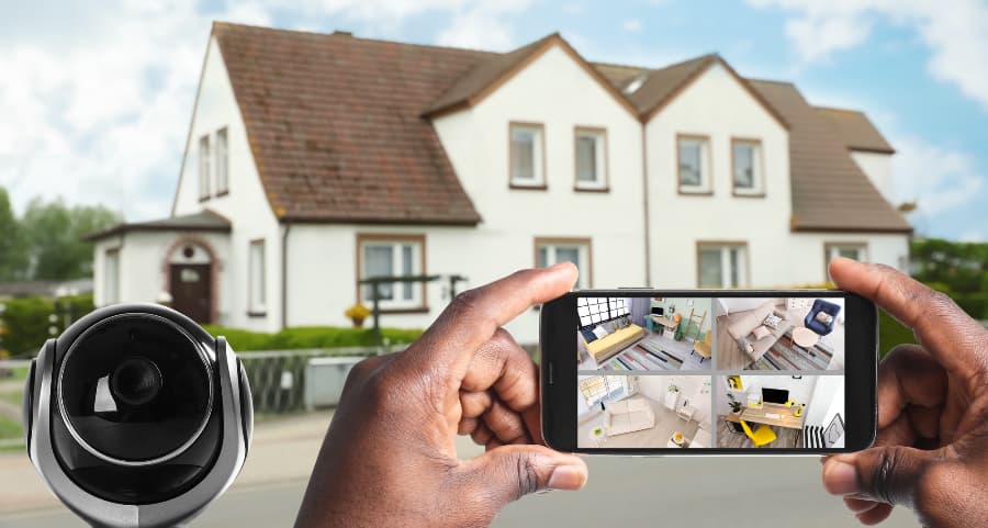Man holding mobile device and checking streams from security cameras